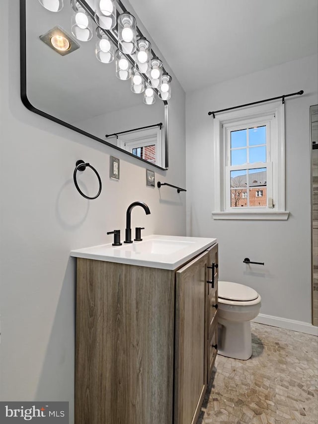 full bathroom with vanity, toilet, and baseboards