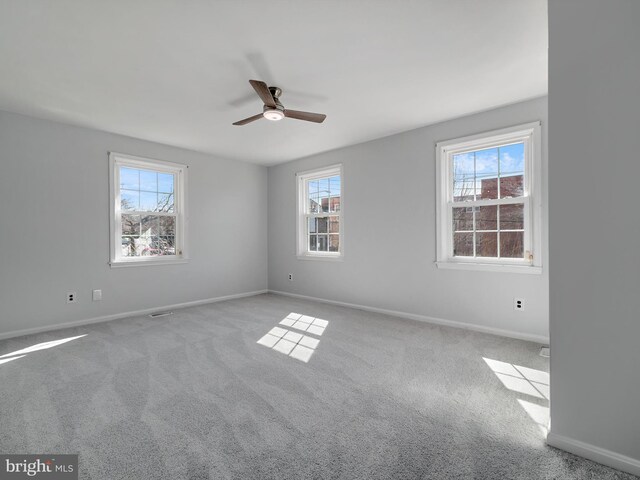 unfurnished room with baseboards, carpet flooring, and a healthy amount of sunlight