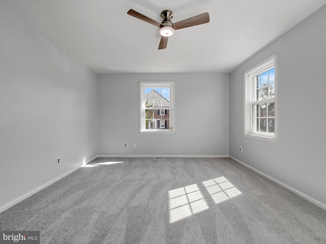 carpeted spare room with ceiling fan and baseboards