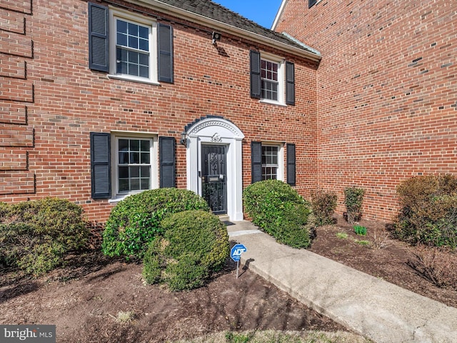 view of exterior entry featuring brick siding