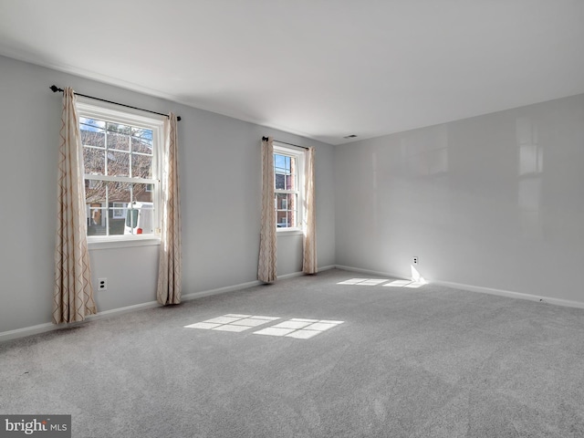 carpeted empty room with baseboards