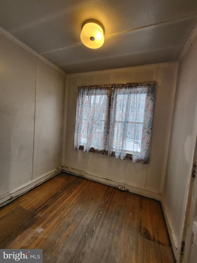 empty room featuring crown molding and hardwood / wood-style floors