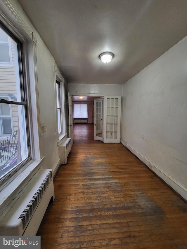 interior space featuring dark wood-type flooring, a baseboard heating unit, and french doors