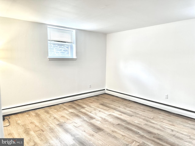 spare room featuring light wood-type flooring and baseboard heating