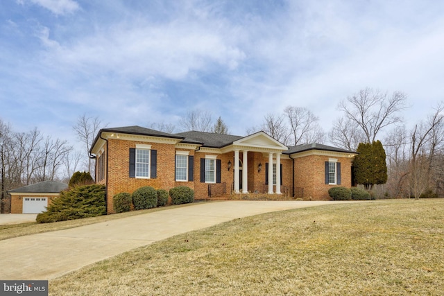 view of front facade featuring an outbuilding, a garage, and a front lawn