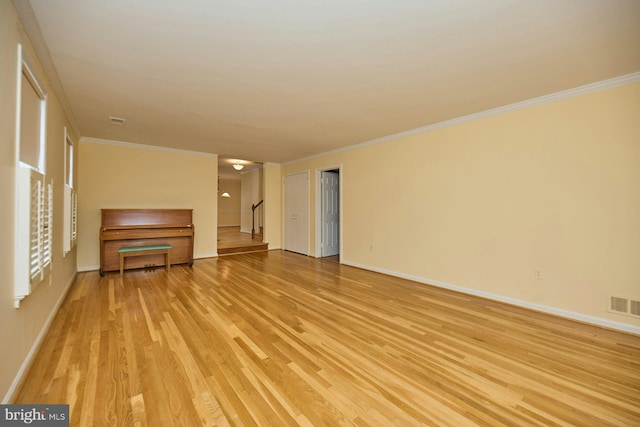 unfurnished living room featuring light hardwood / wood-style floors and crown molding