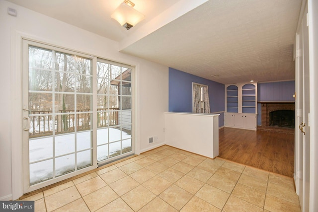 tiled empty room featuring a fireplace