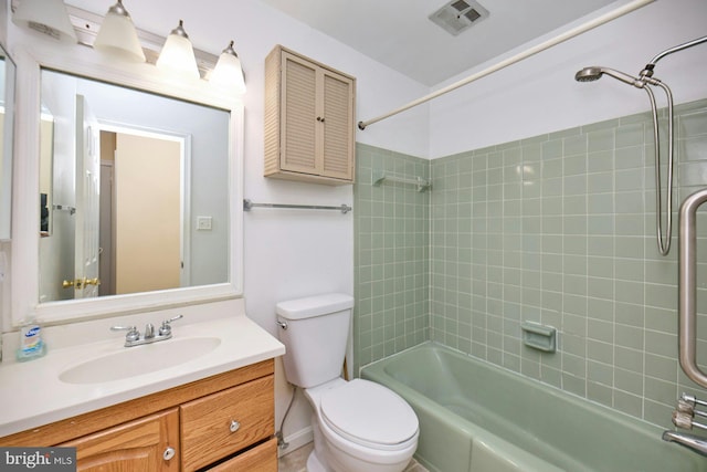 full bathroom with tiled shower / bath combo, toilet, and vanity