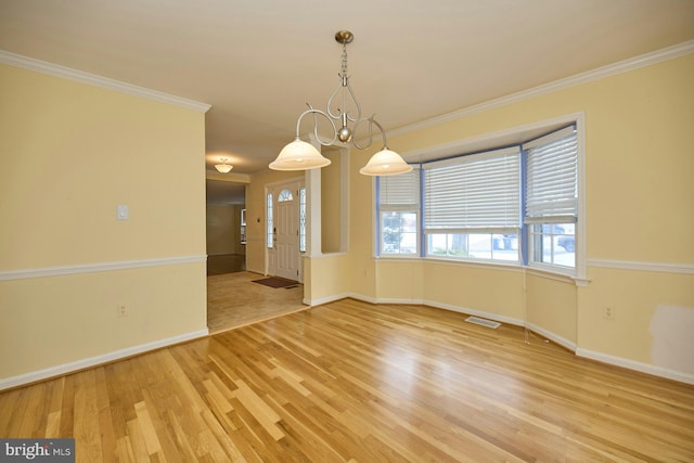 spare room featuring hardwood / wood-style floors and crown molding