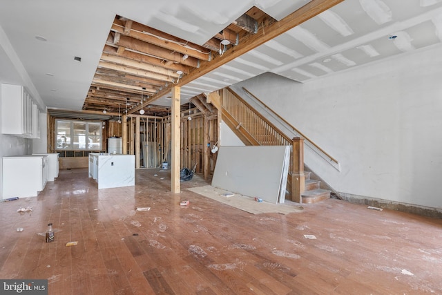 basement featuring water heater and wood-type flooring