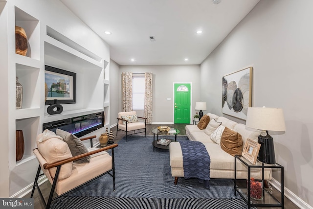 living room with built in features and hardwood / wood-style floors