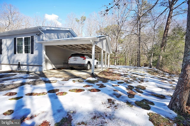 snow covered property featuring a carport