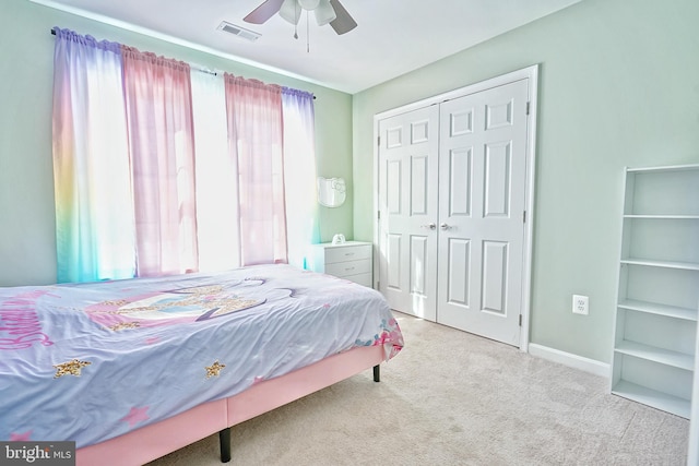 carpeted bedroom featuring ceiling fan and a closet