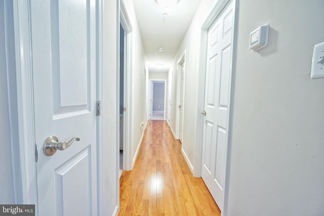 hallway with light hardwood / wood-style floors