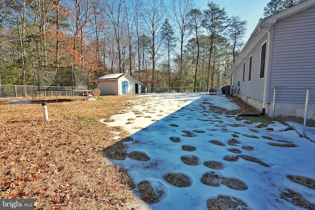 view of yard featuring central air condition unit, a shed, and a trampoline