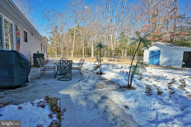 yard covered in snow featuring a storage unit