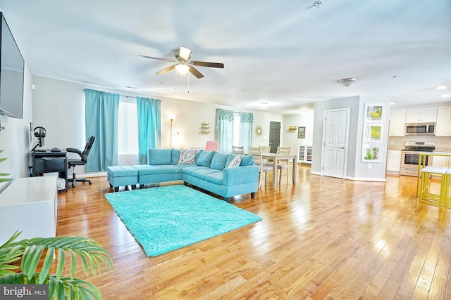 living room with ceiling fan and light hardwood / wood-style floors