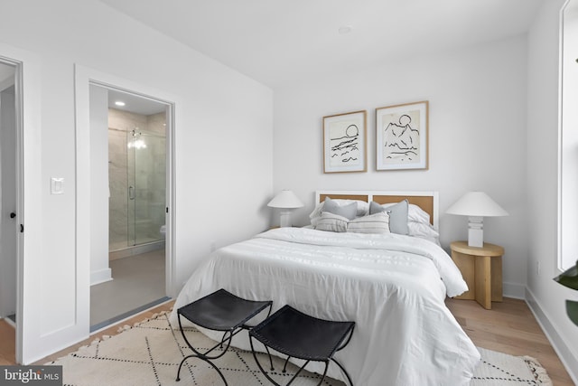 bedroom featuring light wood-type flooring and ensuite bathroom