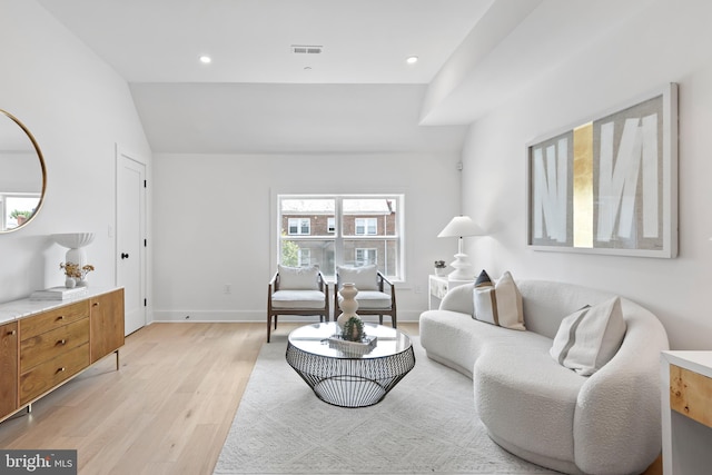 living room featuring vaulted ceiling and light wood-type flooring