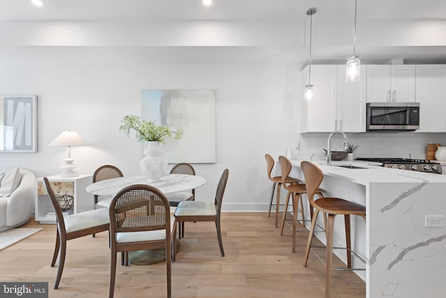 dining space featuring sink and light hardwood / wood-style floors