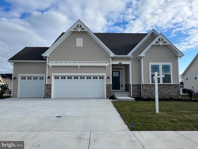 craftsman-style home with a front lawn, a garage, and cooling unit