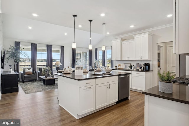 kitchen featuring decorative light fixtures, a center island with sink, stainless steel dishwasher, sink, and white cabinetry