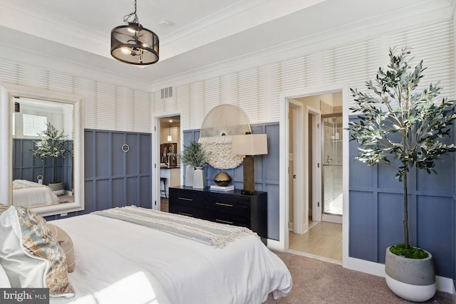 bedroom with carpet floors, connected bathroom, and ornamental molding