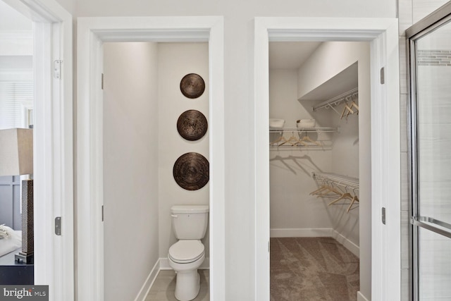 bathroom featuring toilet and a shower with door