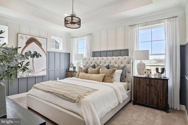 carpeted bedroom featuring ornamental molding and a raised ceiling