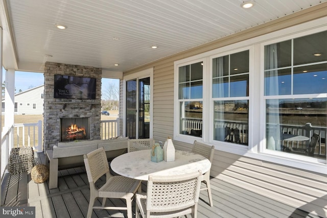 deck with an outdoor stone fireplace