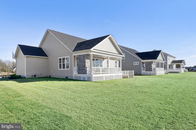 rear view of property with covered porch and a yard