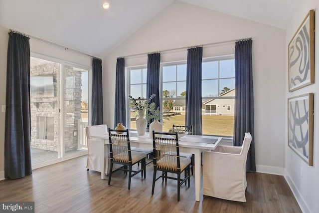 dining space featuring hardwood / wood-style flooring and vaulted ceiling