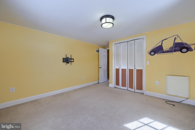 unfurnished bedroom with light carpet and a closet