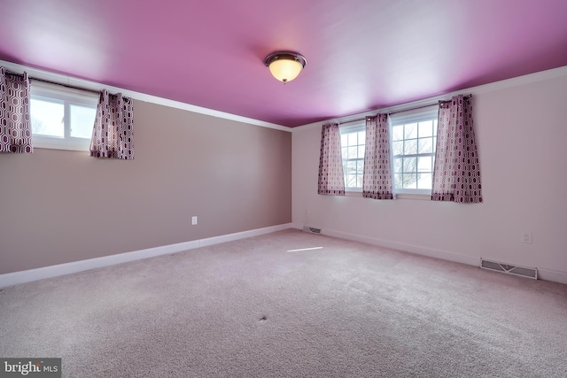 unfurnished room with ornamental molding, carpet flooring, and a healthy amount of sunlight