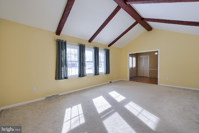 empty room with beam ceiling, high vaulted ceiling, and light carpet