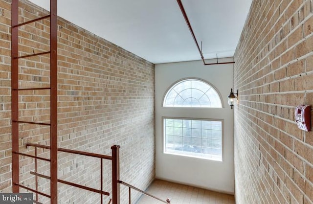 interior space with a healthy amount of sunlight and brick wall