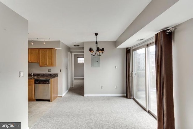 kitchen featuring stainless steel dishwasher, a wealth of natural light, an inviting chandelier, and pendant lighting