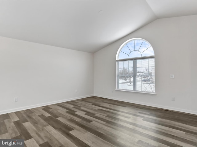 empty room featuring lofted ceiling and dark wood-type flooring