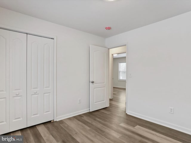 unfurnished bedroom featuring hardwood / wood-style flooring and a closet