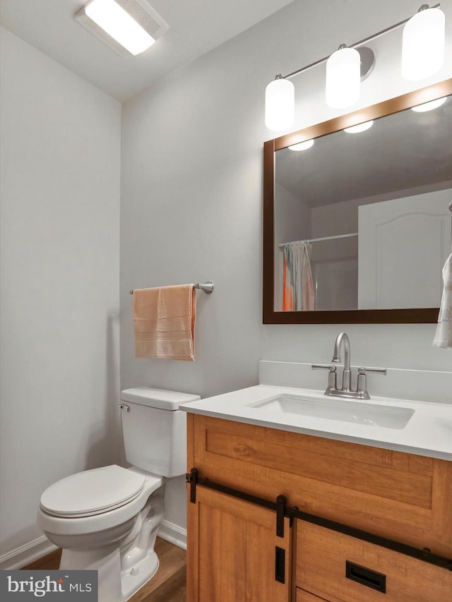 bathroom with vanity, hardwood / wood-style flooring, toilet, and walk in shower