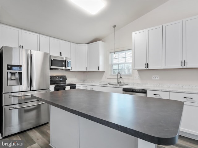 kitchen featuring sink, stainless steel appliances, hanging light fixtures, and white cabinets