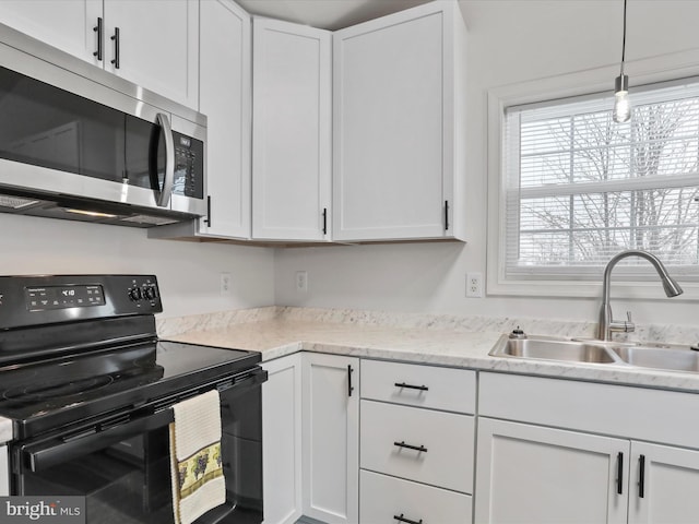 kitchen with black / electric stove, pendant lighting, sink, and white cabinets