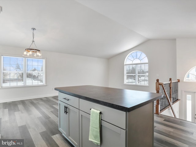 kitchen featuring a kitchen island, dark hardwood / wood-style floors, pendant lighting, lofted ceiling, and gray cabinetry