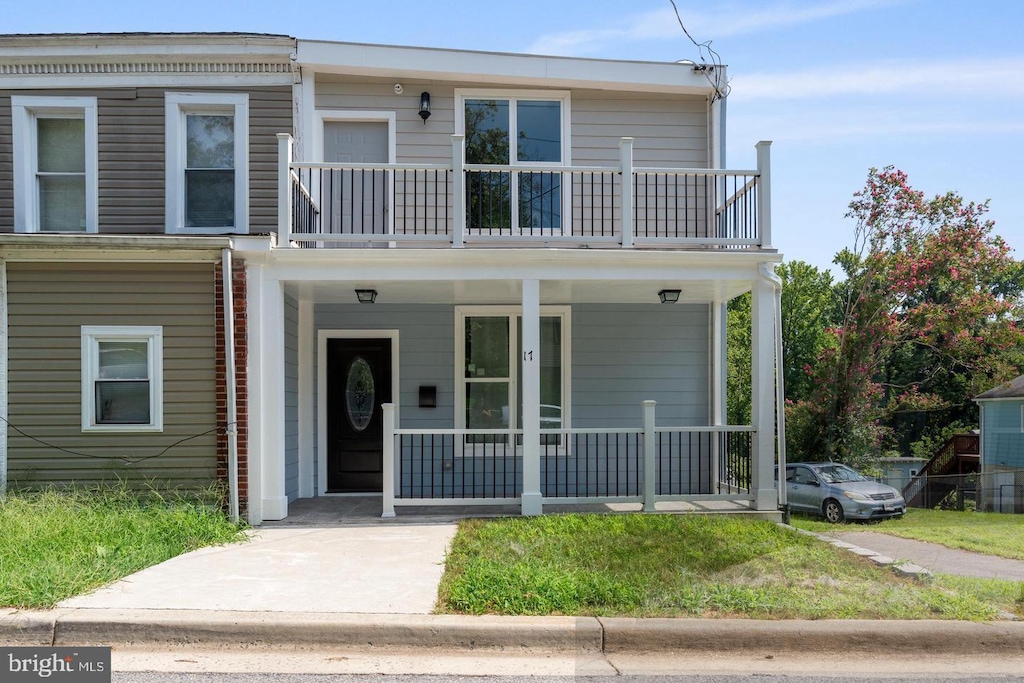 view of front of property featuring covered porch and a balcony