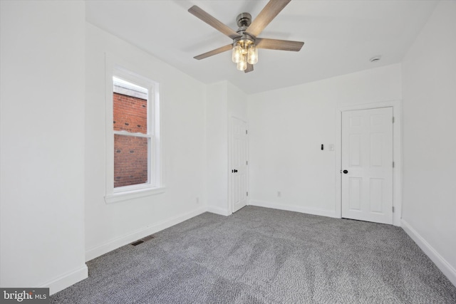 carpeted empty room featuring ceiling fan and plenty of natural light