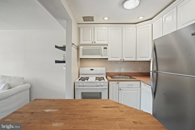 kitchen featuring white cabinetry, white appliances, butcher block counters, and sink