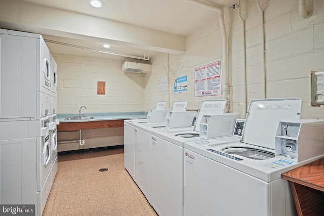 laundry area featuring stacked washer and clothes dryer, sink, and washer and dryer