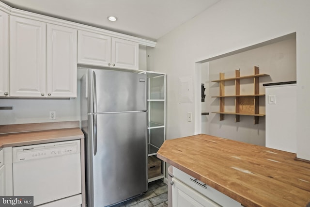 kitchen featuring white cabinetry, wood counters, stainless steel fridge, and dishwasher