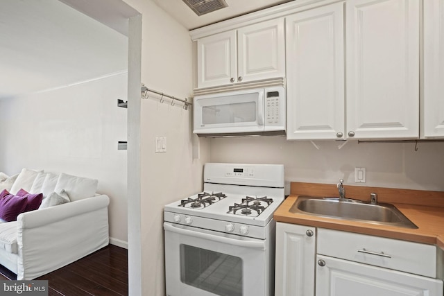 kitchen with white cabinetry, sink, white appliances, and dark hardwood / wood-style floors