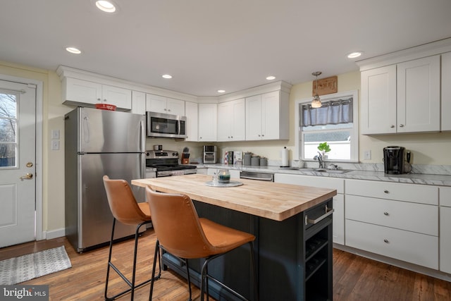 kitchen with sink, a kitchen island, white cabinetry, and stainless steel appliances